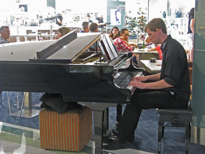 A piano player entertains the coffee drinkers and creates a pleasant atmosphere
