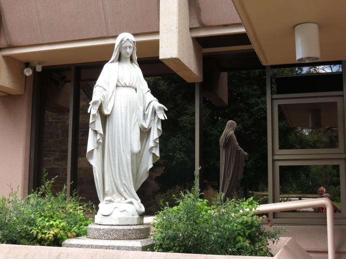Statue of the Virgin Mary reflected in the windows of St Andrews school